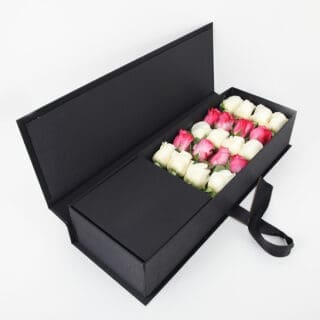 Close-up view of the arrangement of 8 deep purple and 12 white roses in a sleek black box.