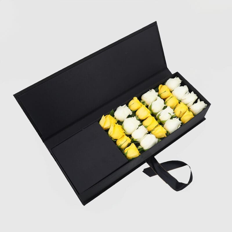 The side view of the sleek black box displays the arrangement of 12 yellow and 12 white roses.