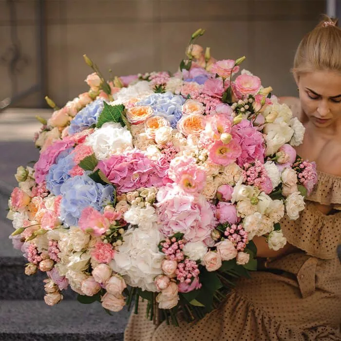 fantasy-bouquet A woman holding a fantasy themed bouquet in baby blue, pink and white colors.