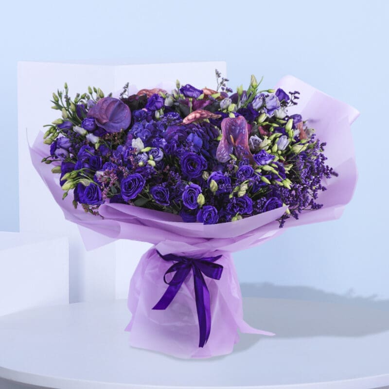 1 (49) Beautiful bouquet of purple flowers arranged in a lavender wrap, elegantly tied with a matching purple ribbon.
