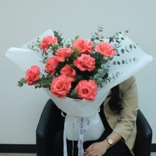 Fresh 10 roses with greenery, neatly wrapped in white and tied with a white ribbon.