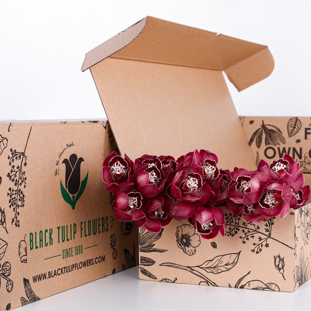 Cymbidium Red 02 A collection of striking Cymbidium Red orchids arranged in a cardboard box, highlighting their beauty and vivid hue.