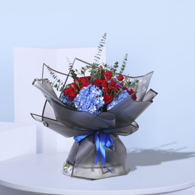 1 (20) Stunning floral gift of red roses and blue hydrangeas, wrapped in black paper with a blue ribbon