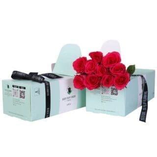 A mint green box containing 10 stem dark pink roses with flower food.
