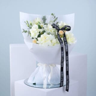 Flower Delivery Service Dubai: Spreading Love with Fresh Flowers Across the City 7 Bouquet of white and peach flowers with eucalyptus in a white wrap tied with a white ribbon and accompanied by a black ribbon.