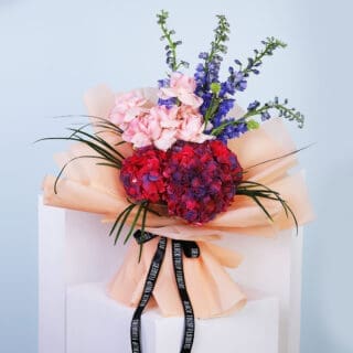 Vibrant hydrangea bouquet in peach wrapping paper.
