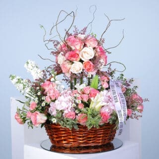 Pink floral arrangement, roses, hydrangeas, pink flowers, basket arrangement.