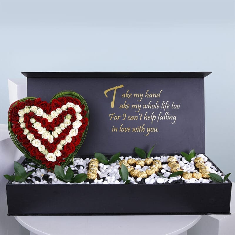 A gift box with a heart-shaped red and white rose arrangement, "I L U" spelled with Ferrero and a romantic poem inside.