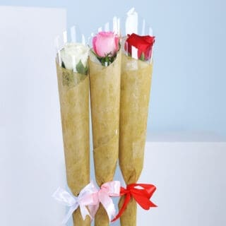 Three wrapped bouquets with pink, white, and red roses, tied with coloured ribbons against a blue background.