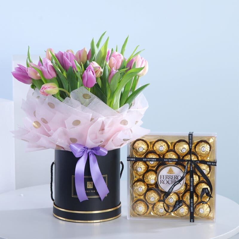 06 A bouquet of pink and purple tulips in a black hat box with a lilac ribbon, next to a box of Ferrero Rocher chocolates