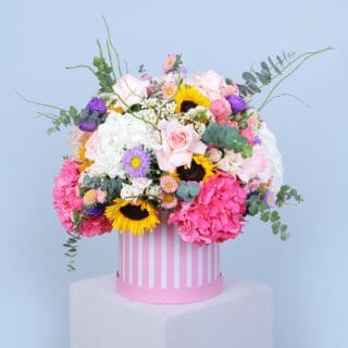 Vibrant summer flower flowers in a pink hatbox, ideal for birthdays and anniversaries.