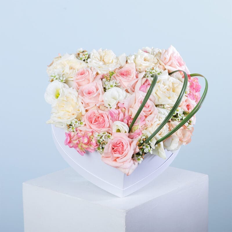 01 Heart-shaped white box with Pink & White O'Hara roses, lisianthus, hydrangea, wax flowers, and steel grass.
