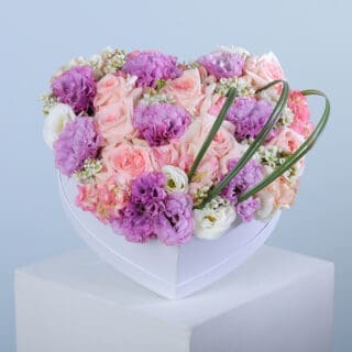 Heart-shaped box containing pink ohara stems, purple lisianthus, pink hydrangea, and stems of wax and steel grass.