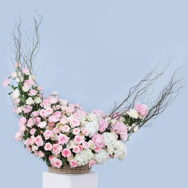 01 Pink rose arrangement with branches and hydrangeas in a basket.