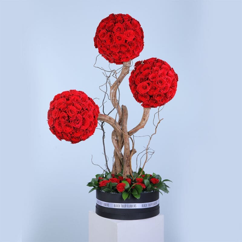 01 A luxurious tree type centerpiece with150 red roses arranged in round shape in three branches.