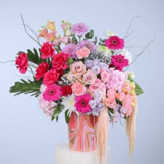Mixed bouquet of red, pink and pale flowers in a basket