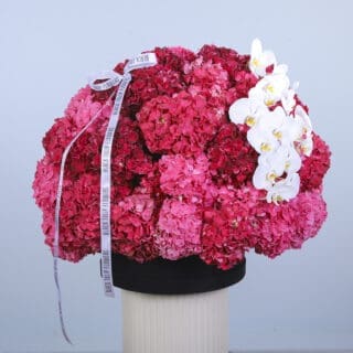 Elegant floral gift - a hat box filled with pink and purple hydrangeas and white orchids.