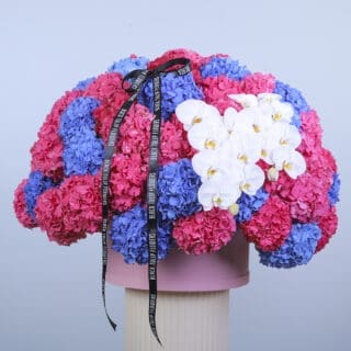 Stunning floral hat box with pink and blue hydrangeas, and white orchids.