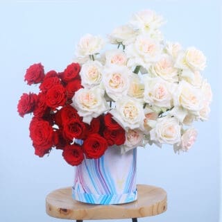 Marble-patterned box with 20 red roses and 30 white O'Hara roses.