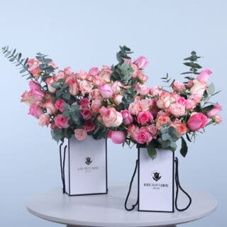 Mixed rose combo featuring pink, Jumelia, and baby roses with fresh eucalyptus in an elegant box.