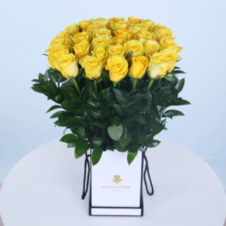 Elegant box containing 30 yellow roses ad green leaves.
