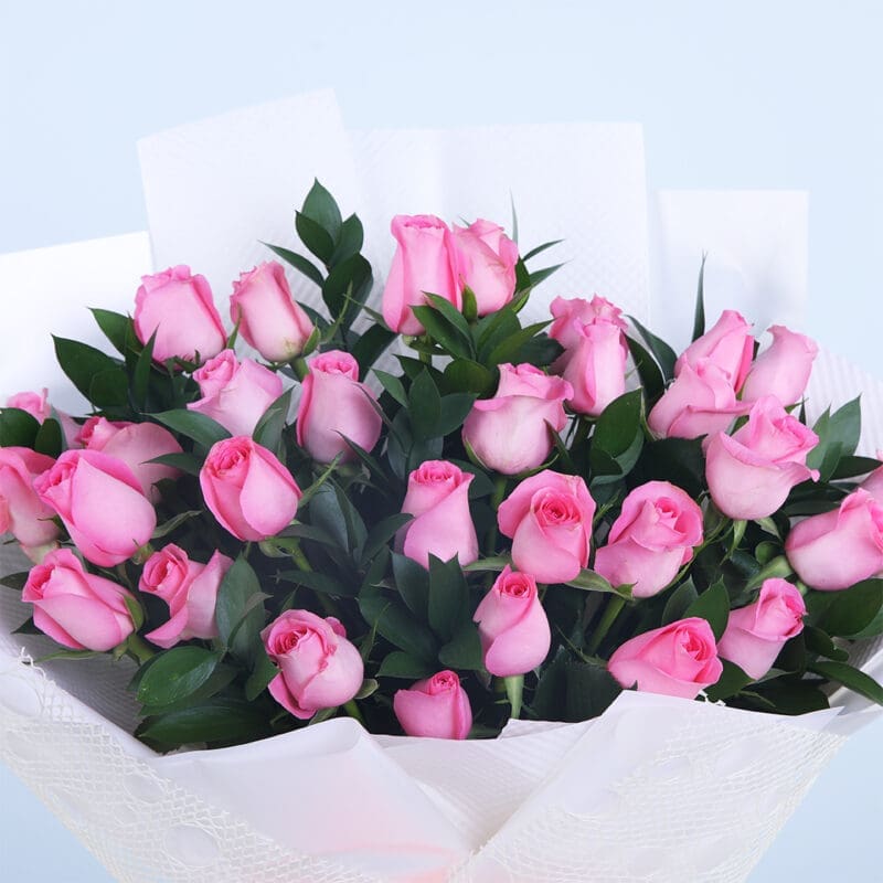 02 - Pretty Pink Rose Bouquet Close-up of a bouquet with 30 pink roses and lush foliage in a white wrap.