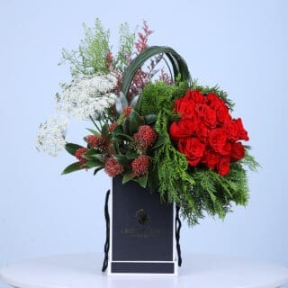 Valentine flower box overflowing with red roses, evergreens, and white blooms, perfect for spreading love