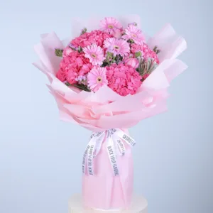 Pink flowers in a bouquet with a white ribbon