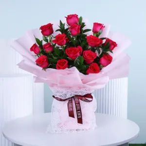 a bouquet of vibrant red roses. The bouquet contains approximately fifteen roses, each with deep red petals and green leaves.