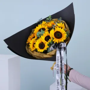 Brighten your day with our Helianthus bouquet, showcasing 10 stems of radiant sunflowers and 3 stems of fragrant Eucalyptus that exude natural beauty and charm.