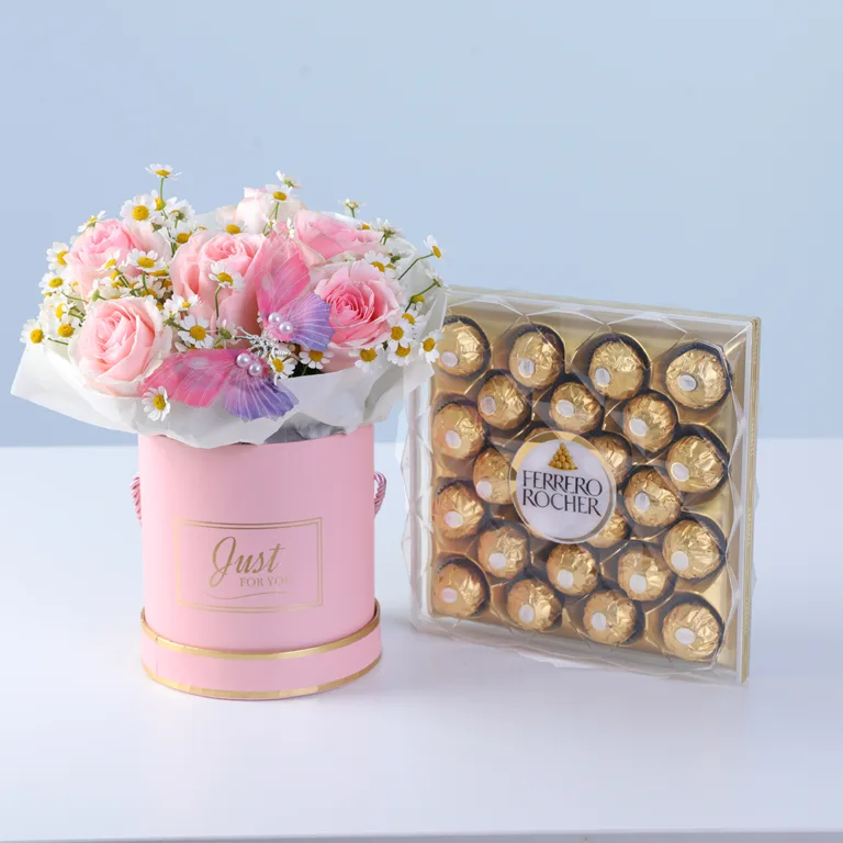 Butterfly-accented flower box with blush pink blooms and Ferrero chocolates arranged in a premium round gift box