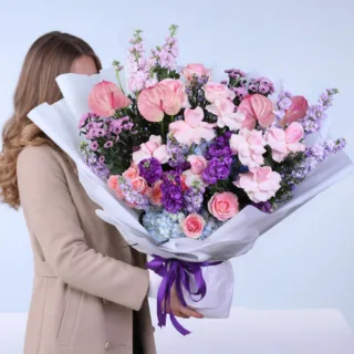 Elegant fresh flower bouquet featuring premium mixed blooms arranged in a stylish hand-tied design, wrapped in decorative paper with ribbon finish, suitable for gifting or decorative use in home and office spaces