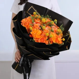 Stylish graduation flower arrangement is thoughtfully designed and wrapped in premium packaging with decorative accents, made as a celebratory gift for success.