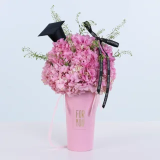 Soft pink hydrangea bouquet with graduation cap for celebrating academic accomplishment and pride