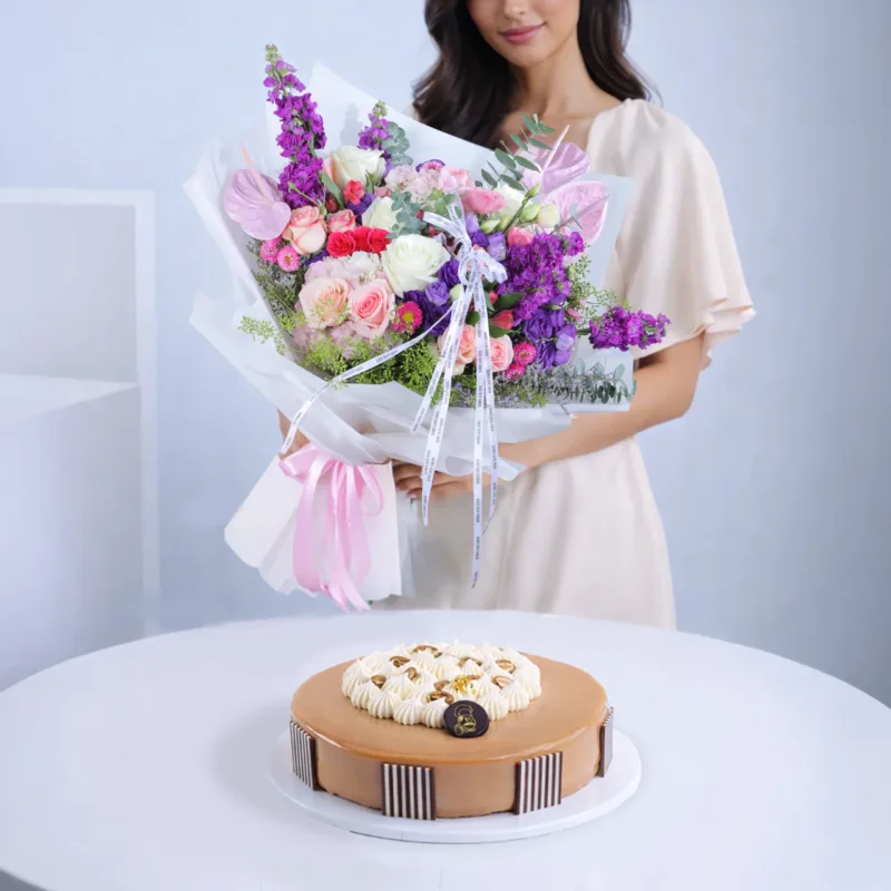 mocha-bloom-fusion-delight A floral and dessert combo featuring fresh mixed flowers placed beside a mocha bean cake in a gift arrangement.