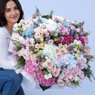 Handcrafted bouquet with soft-colored blooms and textured petals arranged in a refined presentation.