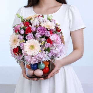 Special Easter pastel bloom vase arrangement with fresh seasonal spring flowers in soft pink, yellow, and white tones, styled in an elegant decorative vase.
