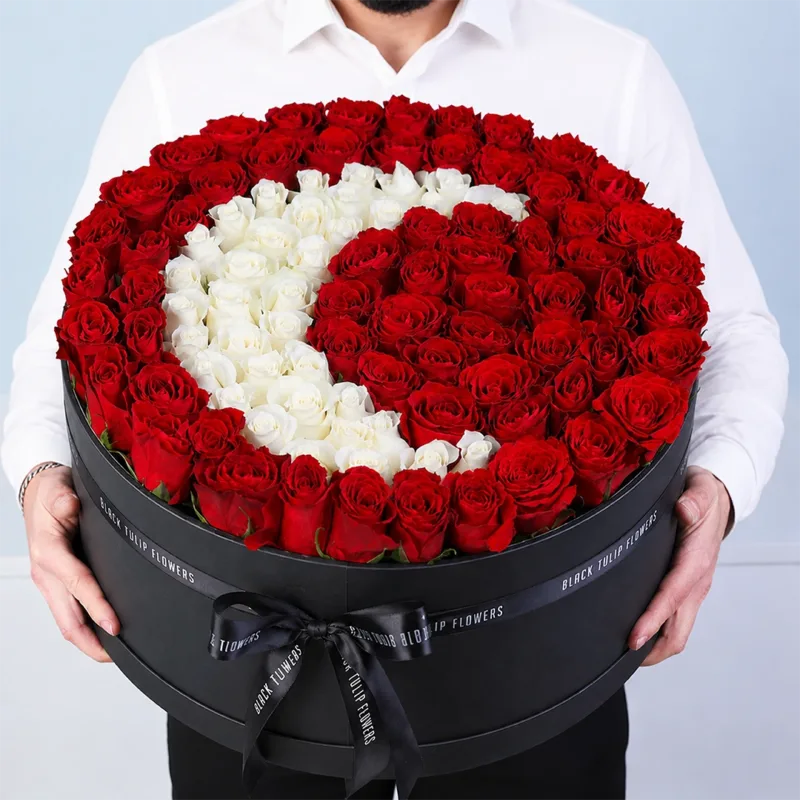 Round box of red and white roses arranged in a crescent shape, elegant floral gift box design
