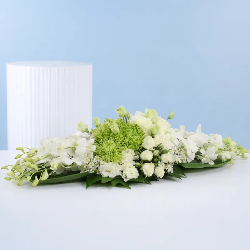 floral-luxe-statement Elegant event table florals arranged with white orchids, green chrysanthemums, white roses, spray roses, layered textures, and lush decorative foliage.