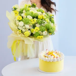 Stylish flower bouquet with cream and yellow blooms paired with a refreshing mango ice cream cake bundle