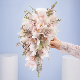 Handheld white orchid cascade bridal bouquet showcasing a luxurious waterfall arrangement designed for classic and contemporary weddings.