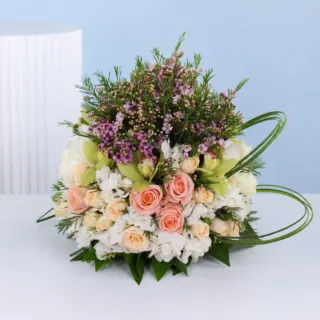 Sophisticated peach floral table décor featuring roses, orchids, hydrangeas, and wax flowers for luxury event styling