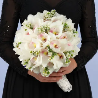 Luxury bridal bouquet featuring white orchids and delicate wax blooms designed for modern bridal styling