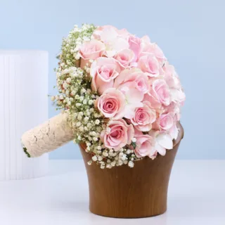 Soft pink rose bridal bouquet with airy white accents, designed to add elegance and charm to wedding-day attire.