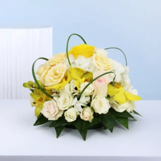 Elegant signature table centrepiece arranged with roses, lilies, and hydrangeas, styled as a premium focal point for weddings and special celebrations