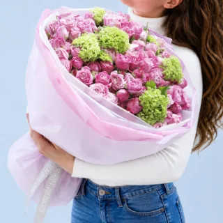 Decorative floral bunch combining white blossoms and vibrant greens with textured foliage for a clean, elegant, and nature-inspired look.