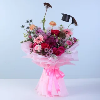 Mixed floral graduation bouquet featuring fresh seasonal blooms like roses, ranunculus, gerberas, and chrysanthemums designed for graduation celebrations.