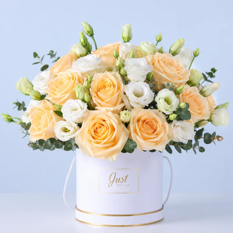 peach-white-harmony-box A charming arrangement of peach and pink roses with delicate buds in a white round box crafted into an elegant floral gift.