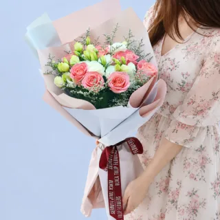 Garden Bloom Hand Bouquet featuring fresh light pink roses, white lisianthus, and white caspia beautifully arranged in an elegant hand bouquet.