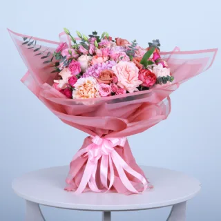 Graceful Pink Rose & Hydrangea Bouquet featuring fresh pink roses, pink hydrangeas, pink spray roses, pink lisianthus, and eucalyptus beautifully arranged in an elegant hand bouquet.